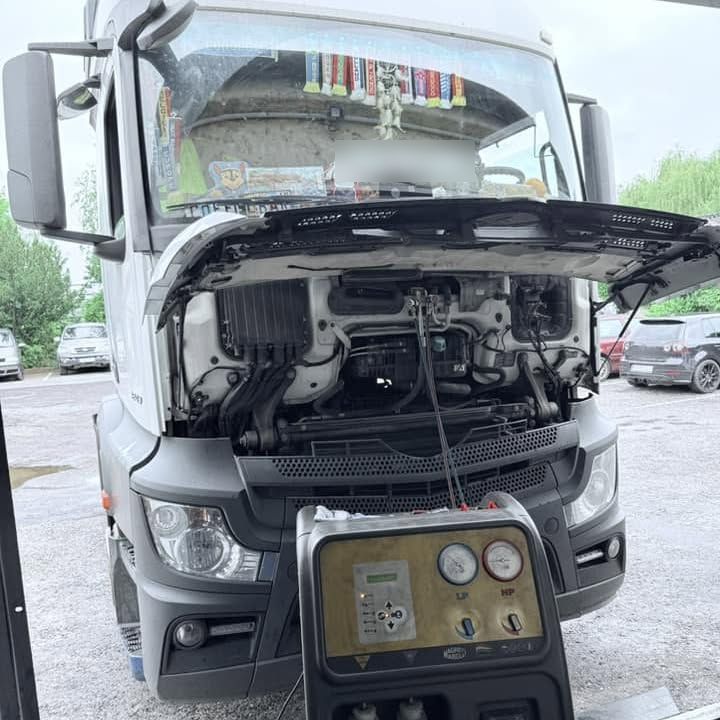 Nákladné auto Mercedes s otvorenou maskou, pred ním stanica na plnenie klimatizácie